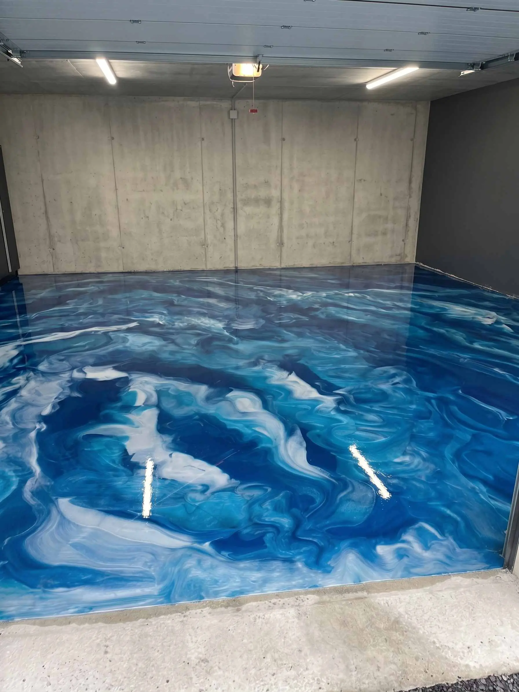 Sol en résine epoxy métallique bleu et blanc dans un garage particulier à Versailles